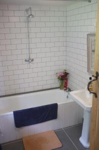 ein Badezimmer mit einer weißen Badewanne und einem Waschbecken in der Unterkunft Bake House Cottage in Shepton Mallet
