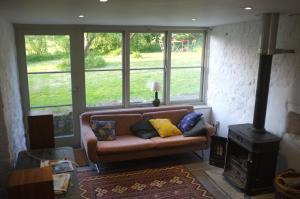 a living room with a couch and a stove at Bake House Cottage in Shepton Mallet