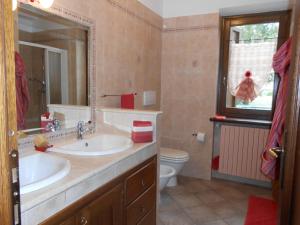 La salle de bains est pourvue de 2 lavabos, de toilettes et d'un miroir. dans l'établissement strada antica, à Novalesa