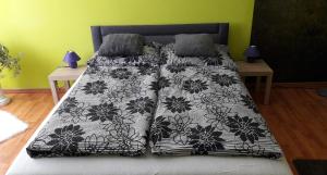 uma cama com um edredão e almofadas preto e branco em Greenapartman em Budapeste