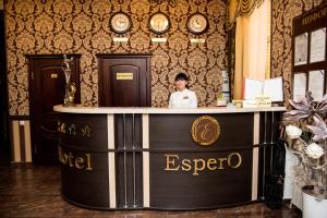 un chef parado detrás de un mostrador en una habitación con relojes en Espero Hotel Resort & Spa, en Yessentuki
