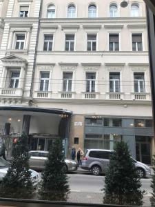 a large white building with cars parked in front of it at Cozy App heart Budapest in Budapest