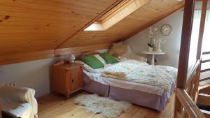 a bed in a room with a wooden ceiling at Fort Janowek in Janówek