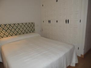 a bedroom with a bed and two sliding doors at Apatamento Gargüera in Trujillo