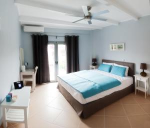 1 dormitorio con 1 cama y ventilador de techo en Villa Despina Green Suites, en Polychrono