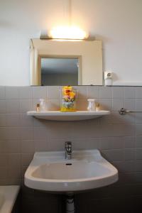 a white sink in a bathroom with a mirror at Le Petit Majestic in Lourdes