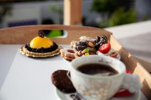 un tavolo con una tazza di caffè e dolci di 5 elementi a Porto Empedocle