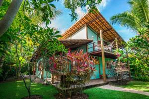 a house in the middle of a garden at Casa Morada dos Pássaros in Imbassai