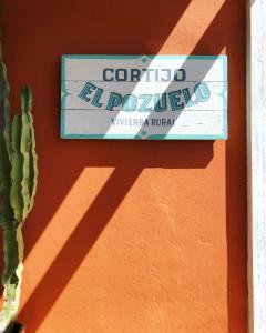 um sinal no lado de uma parede com um cacto em Cortijo El Pozuelo em Tarifa
