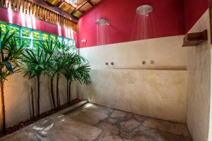 un baño con paredes rojas y plantas. en Casa Morada dos Pássaros, en Imbassai