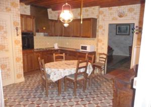 a kitchen with a table and chairs and a table and a kitchen at 2 chambres d'hôtes privées louées séparément avec communs à partager in Beaufort