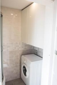 a white washer and dryer in a bathroom at Seaside apartment in Gdańsk