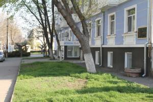 un edificio azul con un árbol delante de él en Old Tiraspol Hostel en Tiraspol
