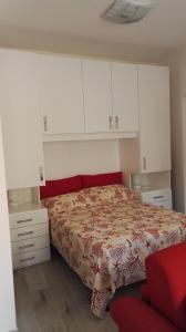 ラ・マッダレーナにあるAppartamento Maddaのベッドルーム(ベッド1台、白いキャビネット付)