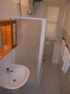 y baño con lavabo y ducha. en Villa Alessia en Paestum