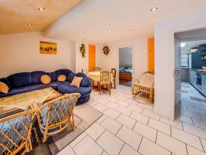 ein Wohnzimmer mit einer blauen Couch und einer Küche in der Unterkunft Gästehaus Eschbach in Monschau