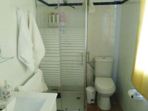 Baño blanco con aseo y lavamanos en Casa Restinga en La Restinga