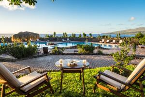a patio with chairs and a table and a pool at Nayara Hangaroa in Hanga Roa