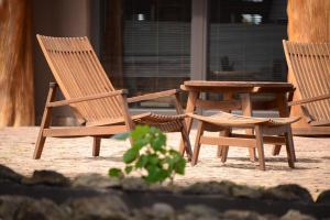 two wooden chairs and a table on a patio at Nayara Hangaroa in Hanga Roa