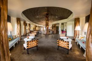 a lobby with tables and chairs and a large ceiling at Nayara Hangaroa in Hanga Roa
