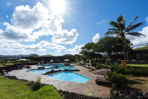 a resort with two pools and a palm tree at Nayara Hangaroa in Hanga Roa