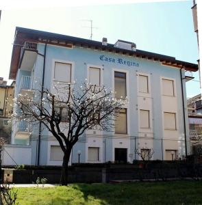 a white building with a tree in front of it at Casa regina in Desenzano del Garda