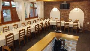 uma sala de jantar com uma mesa longa e cadeiras em PENZIÓN V STAROM MLYNE em Belá