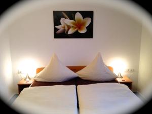 a bedroom with two beds and a picture of a flower on the wall at Hotel zur Wasserburg in Kerpen