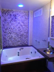 a bathroom with a bath tub and a sink at Hotel La Costa - Adults Only in Rio de Janeiro