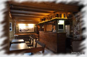 ein Restaurant mit Holztischen und -stühlen und einer Bar in der Unterkunft Konak - Popova Sapka in Popova Shapka