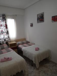 3 łóżka w pokoju z różowymi ręcznikami w obiekcie Apartment Svetlana 2 w Alicante