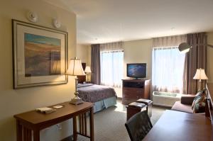 a hotel room with a bed and a desk and a television at Staybridge Suites East Stroudsburg - Poconos, an IHG Hotel in East Stroudsburg