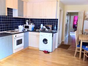 a kitchen with a washing machine in the middle at Finchley Road in London