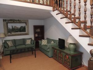 una sala de estar con 2 sofás verdes y una escalera en Apatamento Gargüera, en Trujillo
