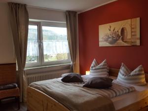 a bedroom with a bed with pillows and a window at Pension Hermes in Wallenborn +45 photos