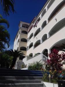 um grande edifício branco com escadas e palmeiras em Marina Bay em Boca Chica