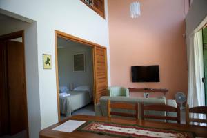 a living room with a couch and a television at Casas em Ilhabela, Linda vista, praia Itaguaçu, Vila Paulino, Colibri, Tuim e Tucano in Ilhabela