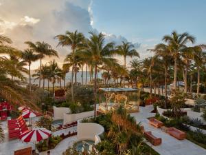 a beach filled with palm trees and palm trees at Faena Hotel Miami Beach in Miami Beach