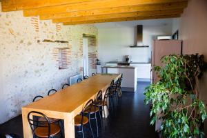 una cocina con una mesa de madera larga y sillas en Gite Pech De Durand Villeneuve Sur Lot, en Villeneuve-sur-Lot