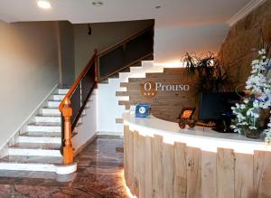 a lobby with stairs and a sign that says o process at Pensión O Prouso in Carnota