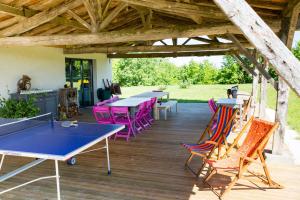 un patio con mesas de ping pong y sillas coloridas en Gite Pech De Durand Villeneuve Sur Lot, en Villeneuve-sur-Lot