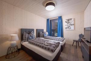 1 Schlafzimmer mit 2 Betten und blauen Vorhängen in der Unterkunft pure mountain BASE in Erpfendorf