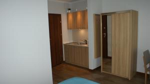 a small kitchen with a sink and a door to a room at Apartament Magdalena in Świnoujście
