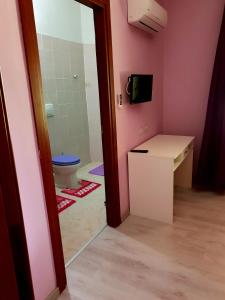 een badkamer met een toilet, een wastafel en een spiegel bij Is Tanas in Serdiana
