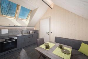 eine Küche mit einem Holztisch und eine Küche mit einem Sofa in der Unterkunft pure mountain BASE in Erpfendorf