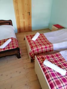 two beds in a room with wooden floors at Ushguli Hotel Riho in Ushguli