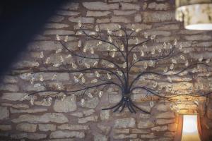 a metal tree wall art on a brick wall at The Lamb Inn in Bourton on the Water