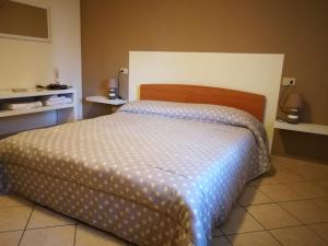 a bedroom with a bed with a blue and white comforter at B&B Covidafranciacorta in Castrezatto