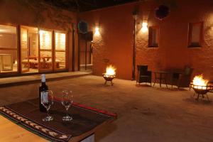 una habitación con 2 copas y una botella de vino en La Casa de Pascual Andino en San Pedro de Atacama