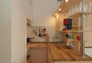 a small kitchen with wooden cabinets and a sink at A cozy wooden studio in a heart of Kharkiv in Kharkiv